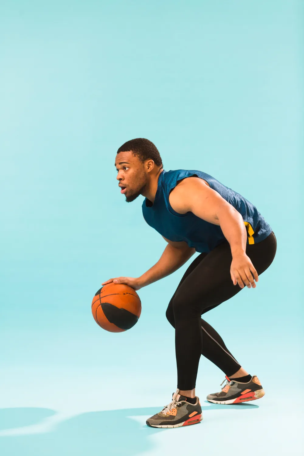 side view of athletic man playing basket ball